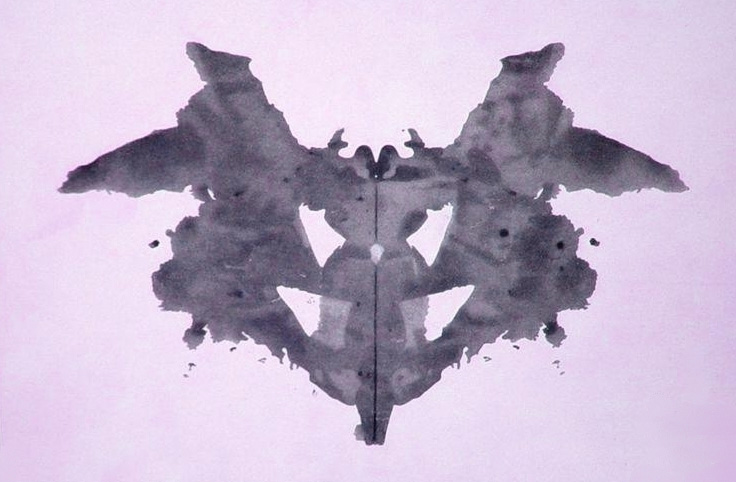 Classic Rorschach inkblot screened in a purple tone.